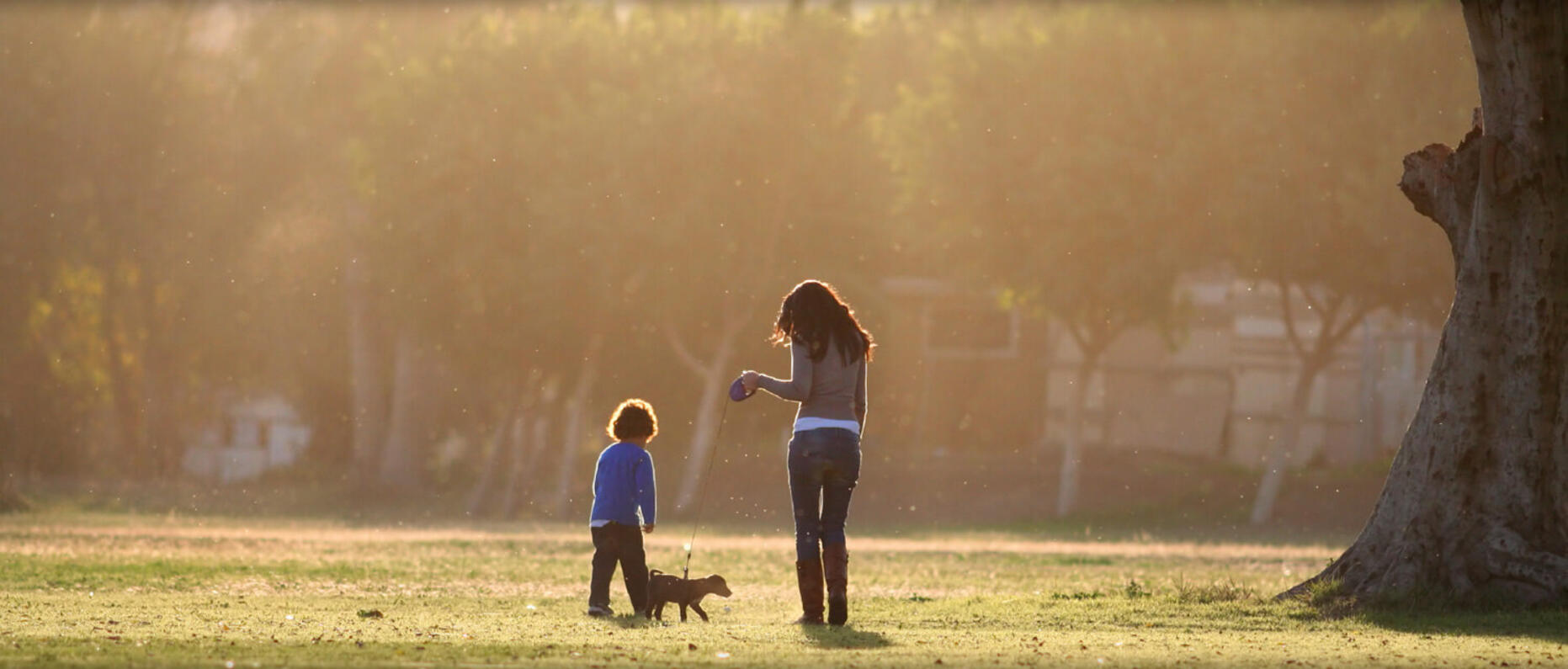 Woman and boy walking puppy
